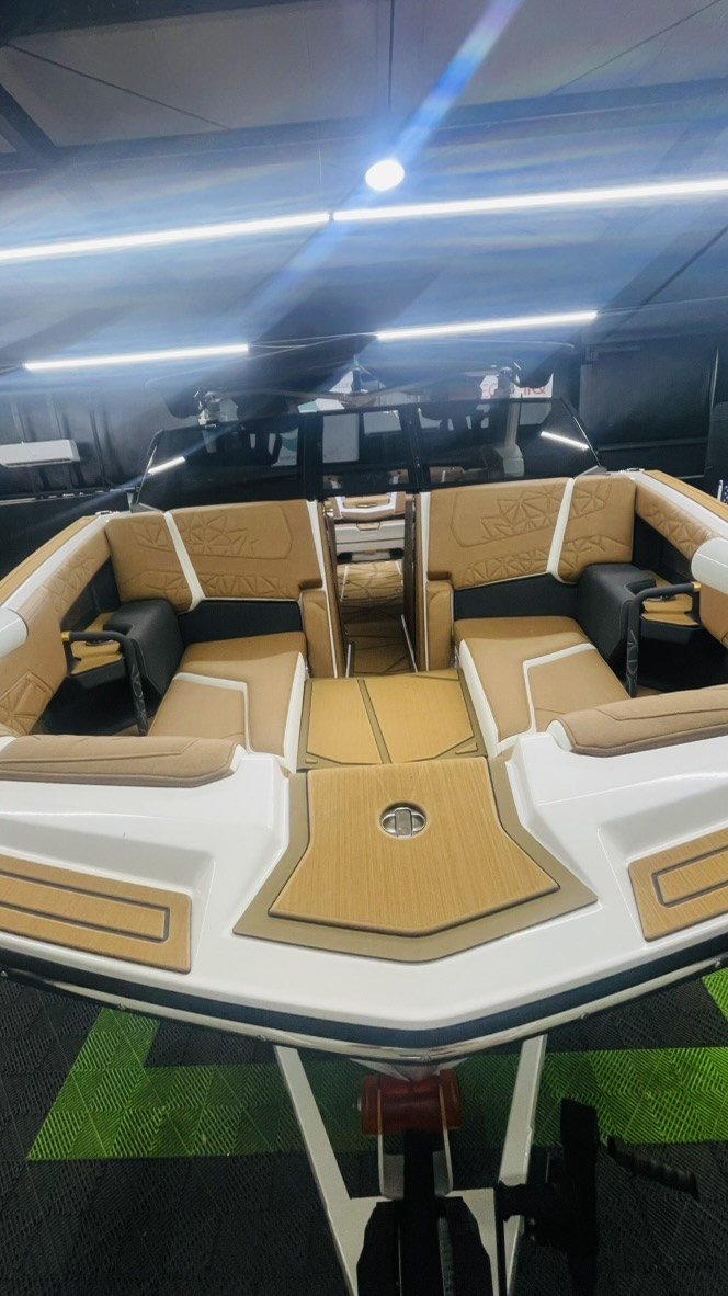 Wake boat interior with tan upholstery and teak-look decking, finished at Elite Auto Spa