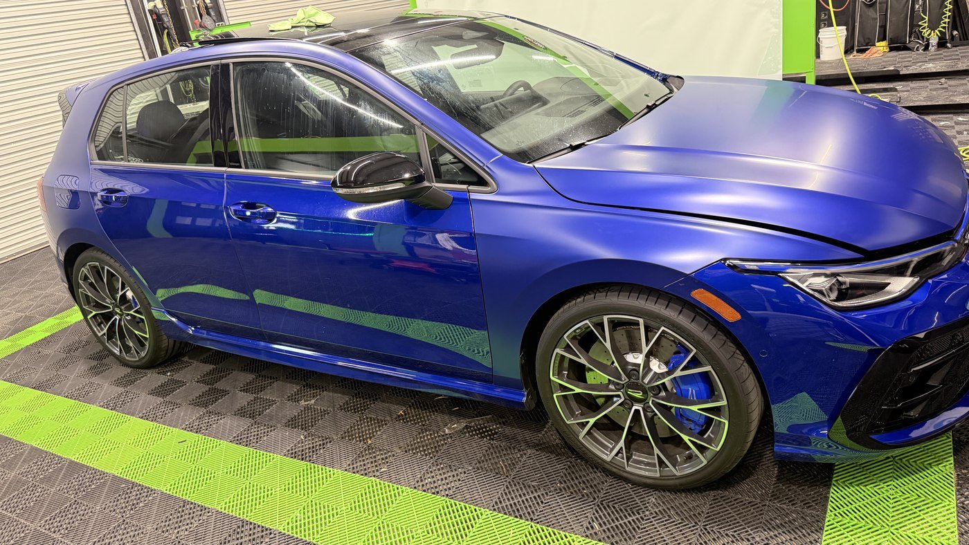 Satin paint protection film going on a blue Volkswagen Golf R