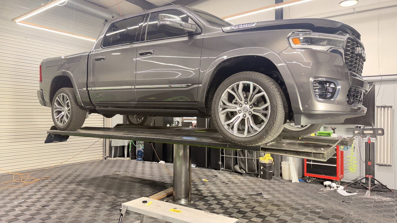 Ram 1500 raised on the lift at Elite Auto Spa so lower panels can be filmed properly